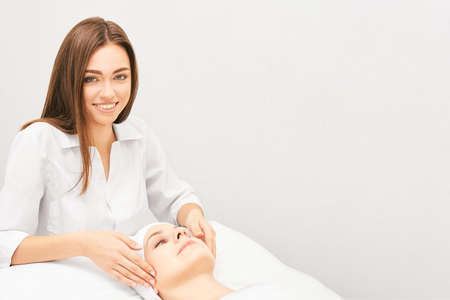 Face professional massage. Spa skincare treatment. Health facial masseur. Girl with doctor hands. Relax cosmetology procedure.の写真素材