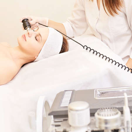 Non injection mesotherapy. Doctor and patient in clinic. Rejuvenation cosmetology tool. Woman...