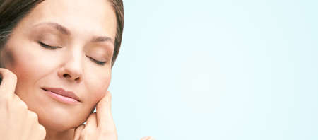 Natural beauty portrait with hands. Cosmetology mature woman face. Cosmetic cream. Skin care. Elegant girl.の写真素材