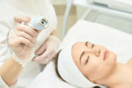 Vacuum face cosmetology equipment. Facial salon cleaning. Youn girl professional skin care. Beauty woman and health device.の写真素材