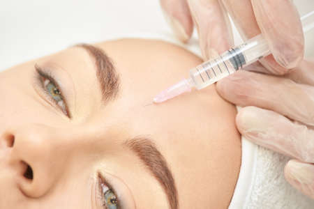 Forehead woman surgery. Anti wrinkle filler. Cosmetology injection. Face skin rejuvenation. Doctor...