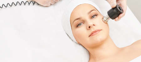 Electroporation woman face treatment. Facial rejuvenation therapy. Cosmetology skin spa equipment. Rf lifting. Massage device.の写真素材