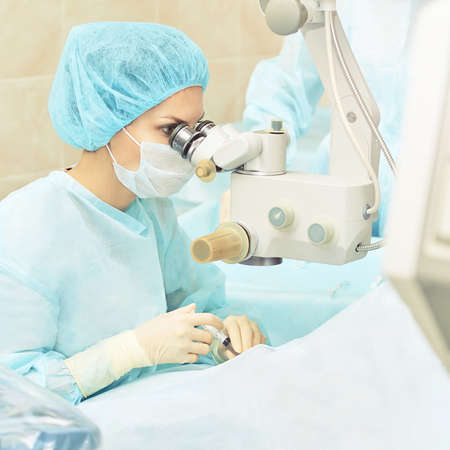 Ophthalmology laser microscope operation. Doctor in clinic. Patient eye treatment. Myopia and cataract removal.の写真素材