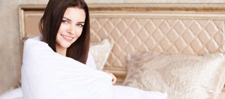 Young beautiful girl sitting at home. Cozy happy morning. Sleepy relax smile woman portrait. Healthy...