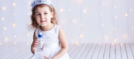 Young little girl hold water bottle. Kid drink cold fresh. Thirsty female person.