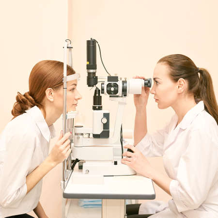 ophthalmologist doctor in exam optician laboratory with female patient. Eye care medical diagnostic. Eyelid treatmentの写真素材