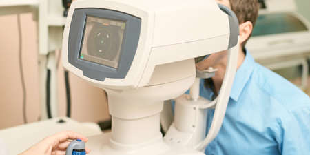 ophthalmologist doctor in exam optician laboratory with male patient. Men eye care medical diagnostic. Eyelid treatment.の写真素材