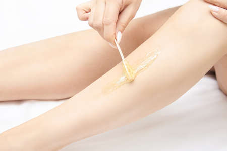 Hair removal at spa luxury studio. Woman legs wax with shugaring. Hot sugar.の写真素材