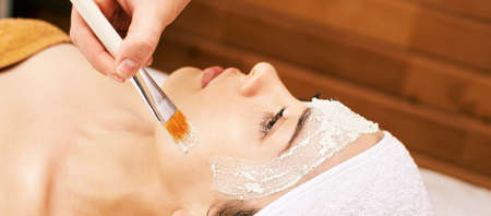 chemic facial peel mask. Cosmetology acne treatment. Young girl at medical spa salon. Brush. Face...