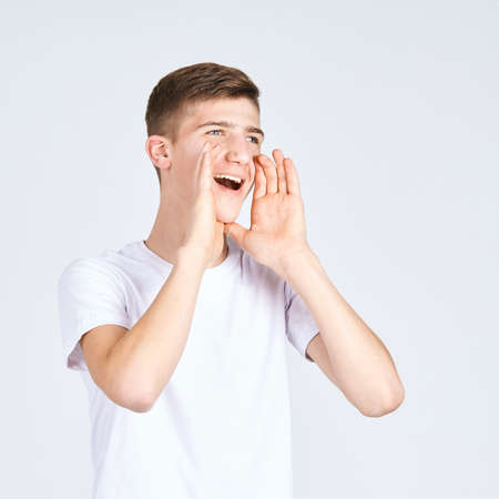 Happy teen man yelling loud. Fun voice concept. Adorable boy portrait. Male sale emotion. Shouting...