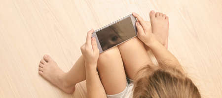 Home office. Young girl holding smartphone with reflection screen. Mock up. Perfect for application....
