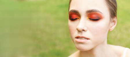 Pretty young woman with bright make up. Outdoor green portrait. park. Happy model face. Mascara...