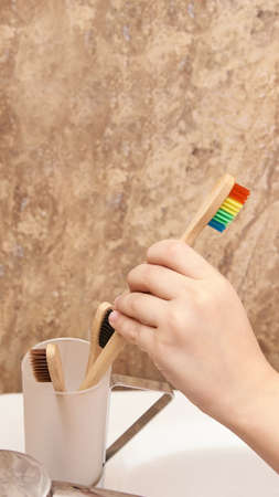 Young girl  dental care. Child wash teeth. Kid clean mouth with eco bamboo toothbrush and bathrobe. Routine home bathroom procedure. Infant oral health cleaningの写真素材