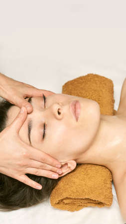 facial woman massage. Hot face masseur. Girl at salon with doctor hands.の写真素材