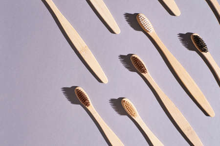 Set of bamboo toothbrushes. Different color. Ecology wood tooth brush group. Grey background. Natural oral hygiene. Dental zero waste protection. Hard shadowの写真素材