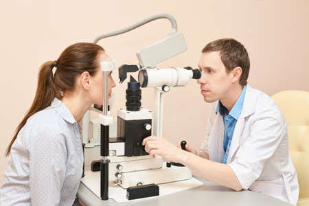 Eye doctor exam patient pressure heath. ophthalmology concept. astigmatism diagnosis at clinic. Eye care consultation service. ophthalmologist looking cataract. Hospital equipmentの写真素材