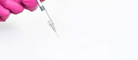 Person in pink glove hold vaccine bottle with syringe. Injection pharmacy concept. Medical nurse...