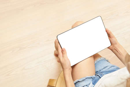 Home office. Young girl holding tablet with white screen. Mock up. Perfect for application....