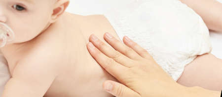 Newborn boy, mother hand. Infant mom massage. funny children change diaper. Home napkin.の写真素材