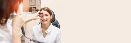 ophthalmologist doctor in exam optician laboratory with female patient. Eye care medical diagnostic. Eyelid treatmentの写真素材