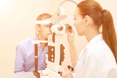 ophthalmologist doctor in exam optician laboratory with male patient. Men eye care medical...