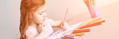 Little girl drawing. Closed Locking Exercise. Homemade routine. School lessons. Write pencil on piece of paper. Kindergarten study. Elementary preschool. Woman kid student. Horizontal bannerの写真素材
