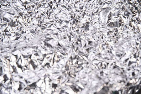 Foil aluminum crushed texture. Metal material background. Silver grunge decoration. Material pattern. Crinkle chrome paper. Fabric shine sheet. Grey color. Copyspace for textの写真素材