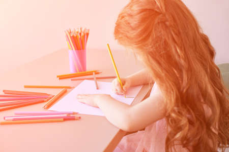 Little girl drawing. Closed Locking Exercise. Homemade routine. School lessons. Write pencil on piece of paper. Kindergarten study. Elementary preschool. Woman kid studentの写真素材