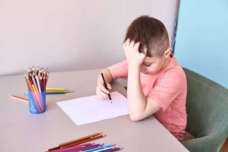 Little boy drawing. Closed Locking Exercise. Homemade routine. School lessons. Write pencil on piece...