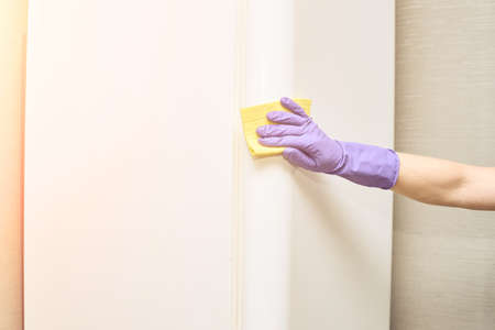Hand in protective glove cleaning fridge. White kitchen furniture. Freezer store clean. Home worker. Housework lifestyle. Professional hygiene housekeeping. Person armの写真素材