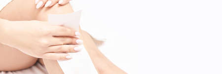 Hot hair removal depilation. Female skin routine. Sugar bodycare. Wax correction. Home leg care routine. Light background. Sugaring cosmetics. Girl self treatment. Horizontal banner with copyspaceの写真素材