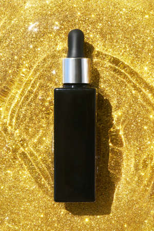 Serum in black tube. Gold wave water.の写真素材