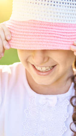 Little girl. Outdoor lifestyle. Dental care smile. Faceless summer portrait. Big hat. Anonymous...