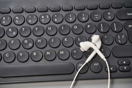 Podcast record. headphone at computer keyboard.の写真素材