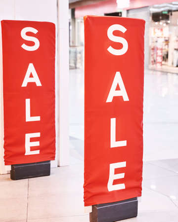 Sale red sign at mall. Discount concept. Market interior design. Selling business model. Lifestyle promotion. Store promo graphic. Shop background. Cheap boutique. Retail commercial price. Money offerの写真素材