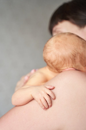 Newborn tiny arm. Mother holding little people. Healthcare concept. Unrecognised modern parenthood. Comfort and safety sleep on shoulder. Human insurance. Family miracle. No faceの写真素材
