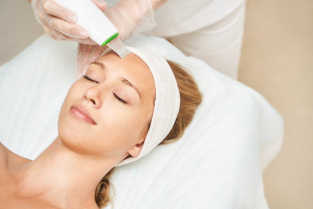 Ultrasonic skin equipment. Woman face cosmetology treatment. Female clinic facial procedure. Anti acne surgery cleaning. Dermatology spa mask. Detox therapy. Rejuvenation skincare beautyの写真素材