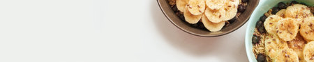 Healthy breakfast. Top view. Oatmeal with banana and flax seeds at bowl. Berry in plate. Organic meal recipe. Vegan cook. Minimalism granola. Hot porrigde with fruit. Banner, copyspaceの写真素材