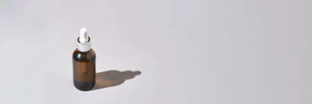 Serum dropper at grey background. Haircare routine. Skin care collagen repair. Hard shadow. Laboratory liquid facial lotion. Cosmetics product. Homemade. Copyspace. Hard trend shadowの写真素材