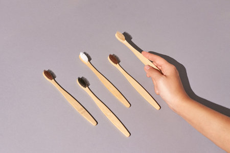 Hand holding toothbrush. Bamboo eco brush. Dental sustainable concept. Layout. Morning home routine....