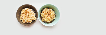 Healthy breakfast. Top view. Oatmeal with banana and flax seeds at bowl. Berry in plate. Organic meal recipe. Vegan cook. Minimalism granola. Hot porrigde with fruit. Banner, copyspaceの写真素材