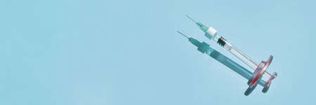 Syringe drug. Doctor injection vaccine. Hard shadow. Healthcare therapy. Cosmetology treatment. Age skin rejuvenation. Beauty science laboratory. Virus concept. Blue backgroundの写真素材