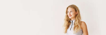 Young pretty woman portrait. Healthy lifestyle. Long blond hair. Smiling female person. Yoga gymnastics. Light background. Caucasian face skin care. Horizontal banner. Copyspaceの写真素材