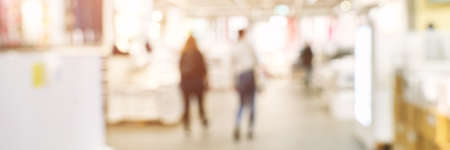 Blurry people at shop store. Defocused mall interior bakground. Crowd business retail market. Franchise backdrop. Copyspace. Exhibition view. Horizontal bannerの写真素材