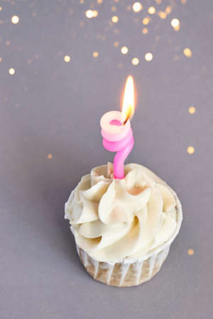 Milky cream cupcake. Birthday sweet bakery. Cookies. Yummy buttercream dessert. Wedding party food. Grey background. Holiday recipe. Anniversary gourmet. One pieces. Candle lightの写真素材