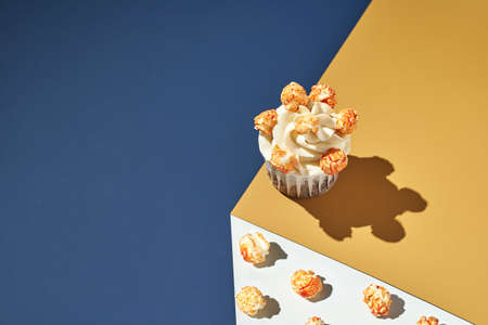 Milky cream cupcake. Birthday sweet bakery. Cookies. Yummy buttercream dessert. Wedding party food. Blue and yellow. Holiday recipe. Anniversary gourmet. One pieces. Candle light. Orange popcormの写真素材