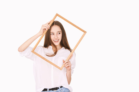 Pretty girl indoor portrait. Light background. Female teenager person. Long brow hair. Out of frame...
