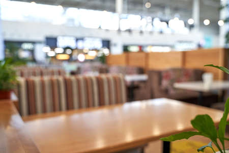 Empty cafe. Social distance. Separate people in restaurant. Dinner table. Waiting food in fastfood cafeteria. Coffee place interior. Blurred background. Blur backdropの写真素材