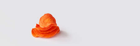 Crispy dried food. Organic tasty chips. Homemade snacks. Sliced carrot. Healthy vegetables. Orange pile Trend natural dish. Horizontal banner. Copyspaceの写真素材