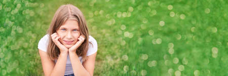 Little girl portrait. Outdoor green background. Looking. Teenager schoolgirl at park. Cute face. Children beauty. Female head. Charisma caucasianの写真素材